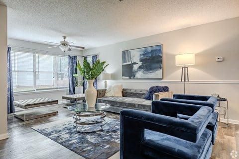 a living room with couches and a table and a ceiling fan